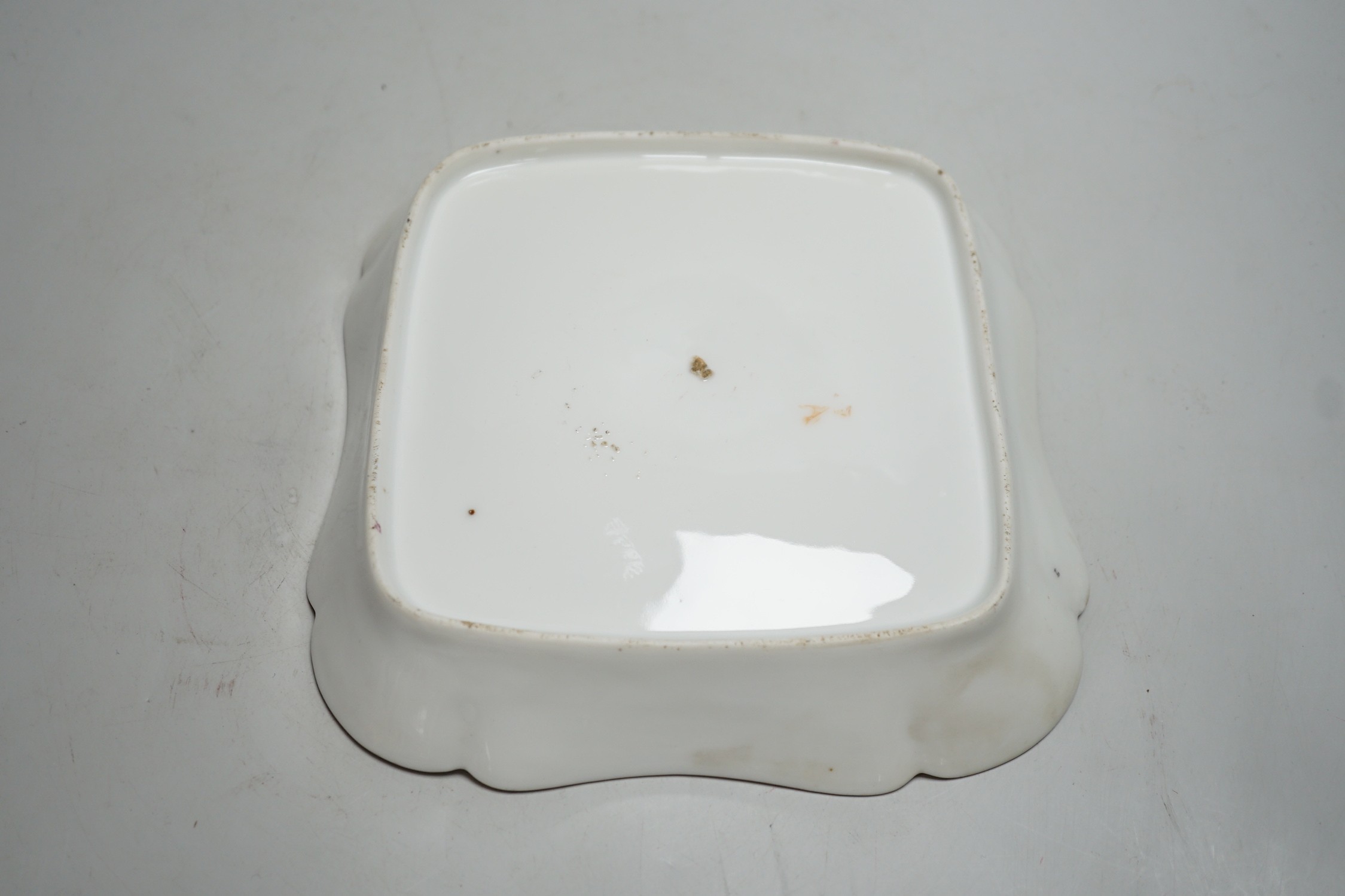 An 18th century Rue Thiroux square shaped dish painted with two bands of pink leaves, and a band of flowers above a central roundel, stencilled crown A mark in orange, the factory was also known as Porcelaines a la Reine